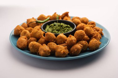 Muson Özel Moong Dal Vada, Pakoda, Dalwada, Pakora veya Mungdal Bhajiya veya Yeşil Chutney ile servis edilen Sarı Börek. seçici odak