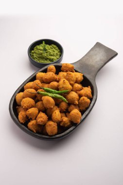 Muson Özel Moong Dal Vada, Pakoda, Dalwada, Pakora veya Mungdal Bhajiya veya Yeşil Chutney ile servis edilen Sarı Börek. seçici odak