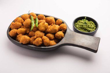 Muson Özel Moong Dal Vada, Pakoda, Dalwada, Pakora veya Mungdal Bhajiya veya Yeşil Chutney ile servis edilen Sarı Börek. seçici odak