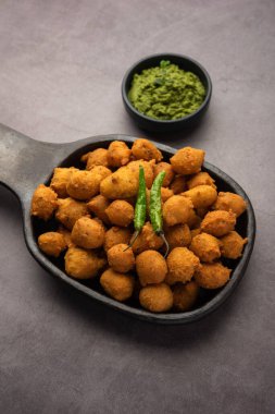 Muson Özel Moong Dal Vada, Pakoda, Dalwada, Pakora veya Mungdal Bhajiya veya Yeşil Chutney ile servis edilen Sarı Börek. seçici odak