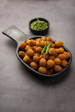 Muson Özel Moong Dal Vada, Pakoda, Dalwada, Pakora veya Mungdal Bhajiya veya Yeşil Chutney ile servis edilen Sarı Börek. seçici odak