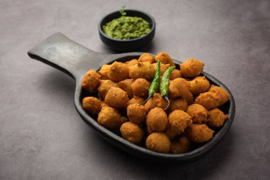 Muson Özel Moong Dal Vada, Pakoda, Dalwada, Pakora veya Mungdal Bhajiya veya Yeşil Chutney ile servis edilen Sarı Börek. seçici odak