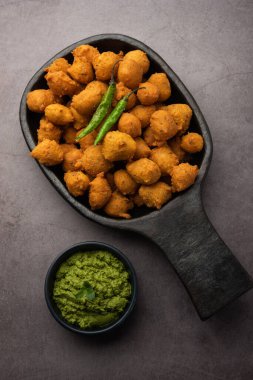 Muson Özel Moong Dal Vada, Pakoda, Dalwada, Pakora veya Mungdal Bhajiya veya Yeşil Chutney ile servis edilen Sarı Börek. seçici odak