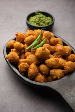 Muson Özel Moong Dal Vada, Pakoda, Dalwada, Pakora veya Mungdal Bhajiya veya Yeşil Chutney ile servis edilen Sarı Börek. seçici odak