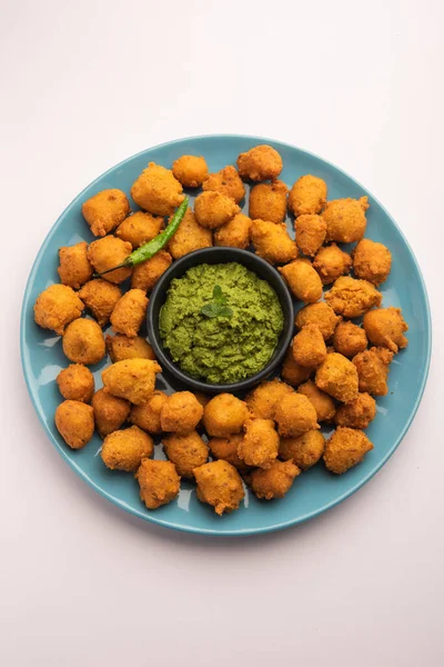 Muson Özel Moong Dal Vada, Pakoda, Dalwada, Pakora veya Mungdal Bhajiya veya Yeşil Chutney ile servis edilen Sarı Börek. seçici odak