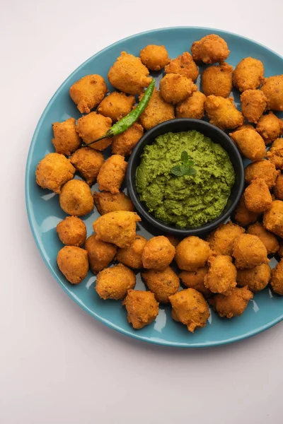 Muson Özel Moong Dal Vada, Pakoda, Dalwada, Pakora veya Mungdal Bhajiya veya Yeşil Chutney ile servis edilen Sarı Börek. seçici odak