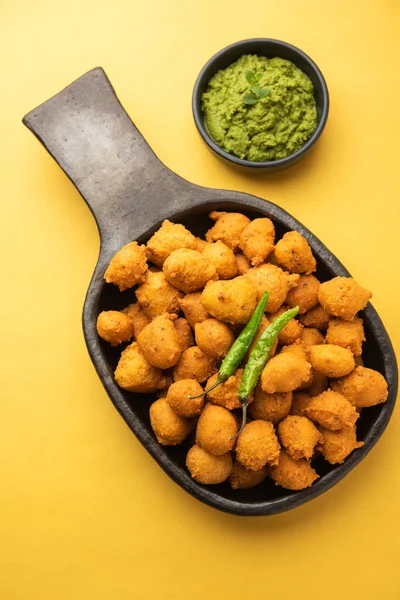Muson Özel Moong Dal Vada, Pakoda, Dalwada, Pakora veya Mungdal Bhajiya veya Yeşil Chutney ile servis edilen Sarı Börek. seçici odak