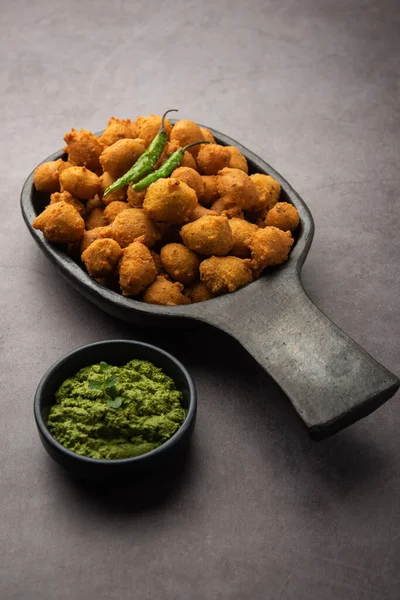 Muson Özel Moong Dal Vada, Pakoda, Dalwada, Pakora veya Mungdal Bhajiya veya Yeşil Chutney ile servis edilen Sarı Börek. seçici odak