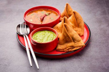 South indian Sambar Samosa Chutney it's a fusion food in which sambhar is from South and Samosas are from North India. served with green chutney. clipart