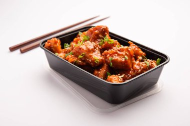 Biberli tavuk, çevrimiçi yemek siparişi için siyah plastik bir konteynıra konur.