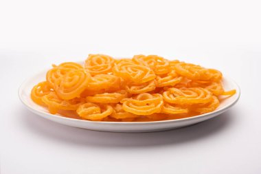 Gevrek tatlı jalebi, jilapi, zulbia, mushabak veya zalabia in white oval plaka. seçici odak