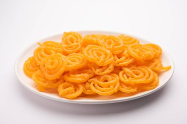 Gevrek tatlı jalebi, jilapi, zulbia, mushabak veya zalabia in white oval plaka. seçici odak