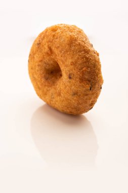 Güney Hindistan Vada, Medu Vada ya da tabakta veya kasede dal vadai, sade arka planda izole edilmiş, seçici odaklı