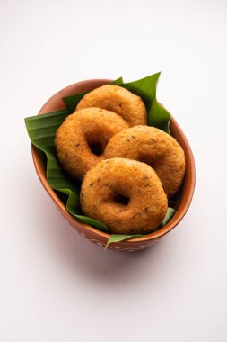 Güney Hindistan Vada, Medu Vada ya da tabakta veya kasede dal vadai, sade arka planda izole edilmiş, seçici odaklı