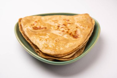 Üçgen şekilli düz paratha veya Parantha, kepekli buğday unundan yapılmış lezzetli Hint düz ekmeğidir. Bir tabakta servis edilir, seçici bir odak