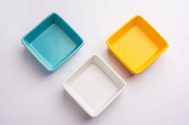 Group of Empty white, yellow and blue ceramic serving bowl, isolated over white or gray background