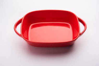 Empty red ceramic serving bowl, isolated over white or gray background
