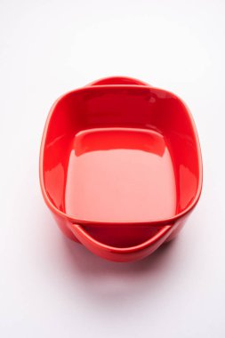 Empty red ceramic serving bowl, isolated over white or gray background