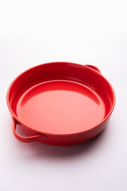 Empty red ceramic serving bowl, isolated over white or gray background