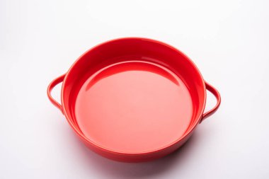 Empty red ceramic serving bowl, isolated over white or gray background