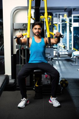 Hintli yakışıklı adam spor salonunda spor yapıyor veya egzersiz yapıyor - sağlık ve spor konsepti