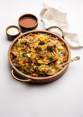 Indian Mutton biryani prepared in Basmati Rice served with Yogurt dip over moody background, Selective focus