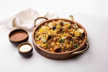 Indian Mutton biryani prepared in Basmati Rice served with Yogurt dip over moody background, Selective focus
