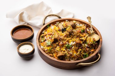 Indian Mutton biryani prepared in Basmati Rice served with Yogurt dip over moody background, Selective focus