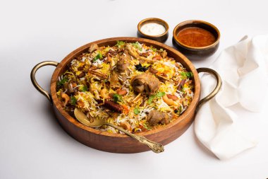 Indian Mutton biryani prepared in Basmati Rice served with Yogurt dip over moody background, Selective focus