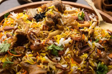 Indian Mutton biryani prepared in Basmati Rice served with Yogurt dip over moody background, Selective focus