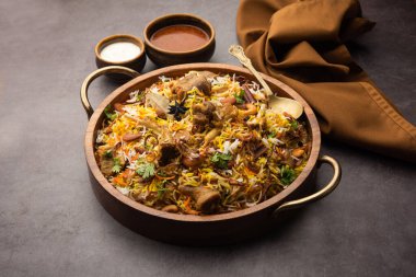 Indian Mutton biryani prepared in Basmati Rice served with Yogurt dip over moody background, Selective focus