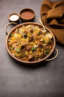 Indian Mutton biryani prepared in Basmati Rice served with Yogurt dip over moody background, Selective focus