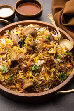 Indian Mutton biryani prepared in Basmati Rice served with Yogurt dip over moody background, Selective focus