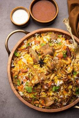 Indian Mutton biryani prepared in Basmati Rice served with Yogurt dip over moody background, Selective focus