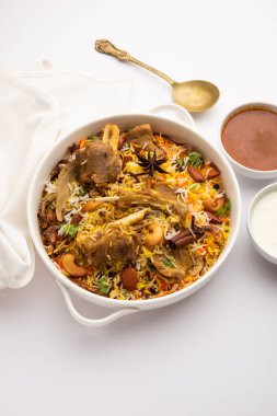 Indian Mutton biryani prepared in Basmati Rice served with Yogurt dip over moody background, Selective focus
