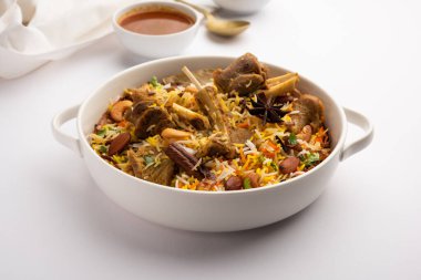 Indian Mutton biryani prepared in Basmati Rice served with Yogurt dip over moody background, Selective focus