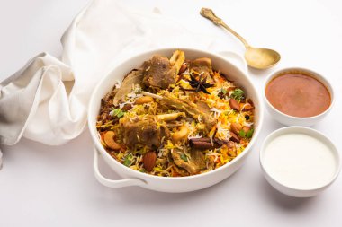 Indian Mutton biryani prepared in Basmati Rice served with Yogurt dip over moody background, Selective focus