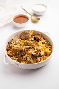 Indian Mutton biryani prepared in Basmati Rice served with Yogurt dip over moody background, Selective focus