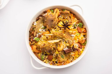 Indian Mutton biryani prepared in Basmati Rice served with Yogurt dip over moody background, Selective focus