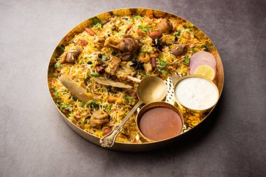 Indian Mutton biryani prepared in Basmati Rice served with Yogurt dip over moody background, Selective focus