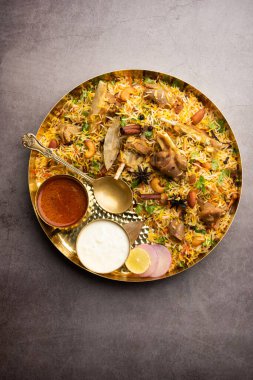 Indian Mutton biryani prepared in Basmati Rice served with Yogurt dip over moody background, Selective focus