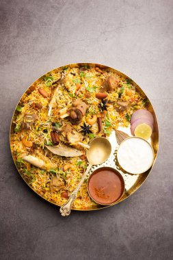 Indian Mutton biryani prepared in Basmati Rice served with Yogurt dip over moody background, Selective focus