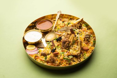 Indian Mutton biryani prepared in Basmati Rice served with Yogurt dip over moody background, Selective focus