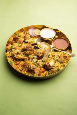 Indian Mutton biryani prepared in Basmati Rice served with Yogurt dip over moody background, Selective focus