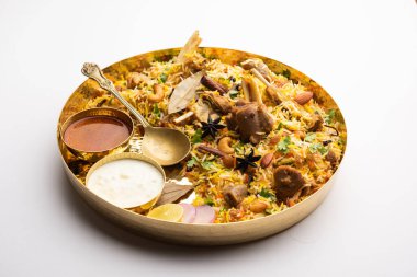 Indian Mutton biryani prepared in Basmati Rice served with Yogurt dip over moody background, Selective focus