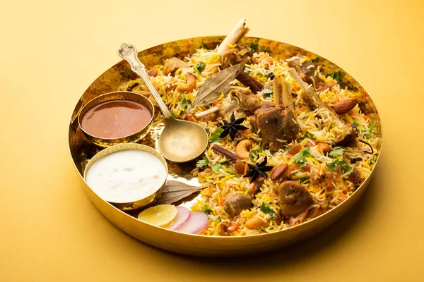 Indian Mutton biryani prepared in Basmati Rice served with Yogurt dip over moody background, Selective focus