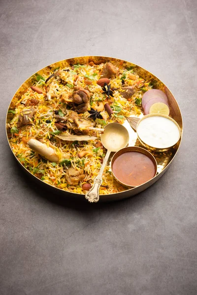 Indian Mutton biryani prepared in Basmati Rice served with Yogurt dip over moody background, Selective focus