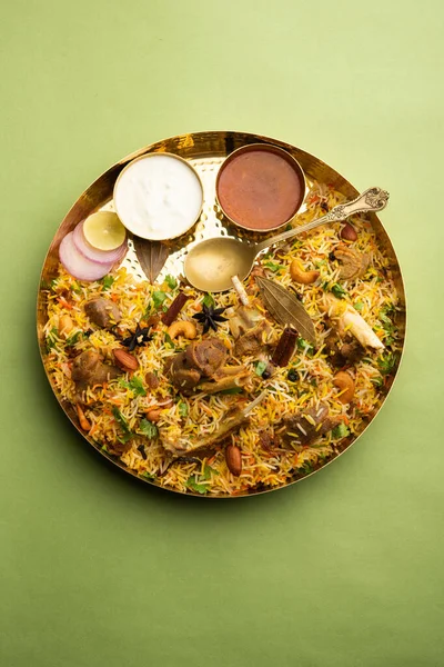 Indian Mutton biryani prepared in Basmati Rice served with Yogurt dip over moody background, Selective focus