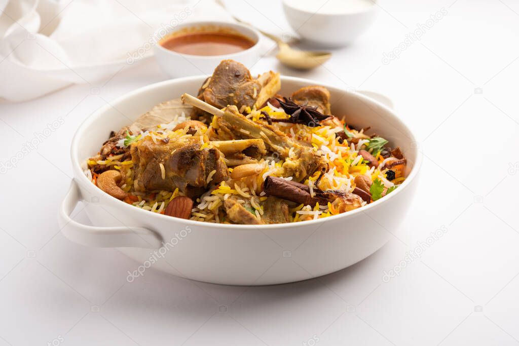 Indian Mutton biryani prepared in Basmati Rice served with Yogurt dip over moody background, Selective focus