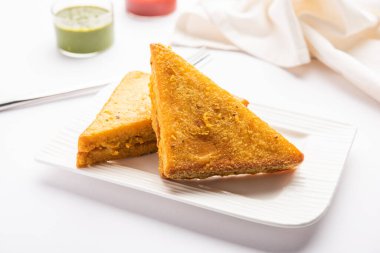 Sandviç ekmeği Pakora ya da Pakoda üçgeniyle servis edilen domates ketçapı, yeşil turşu, popüler Hint çay saati atıştırmalığı.